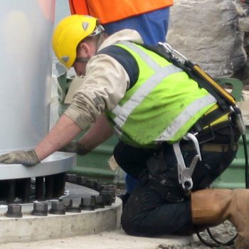 Engineer inspecting base of wind turbine